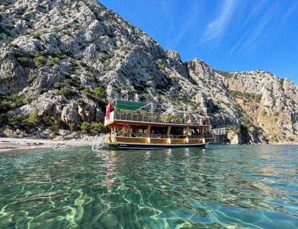 Traditionelles türkisches Ausflugsboot in ruhiger Bucht vor Felskulisse
