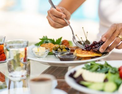 Ein liebevoll angerichtetes türkisches Frühstück mit Oliven, Butter, Marmelade, Käse und Fladenbrot – serviert auf einer Glasplatte im Garten der Lykia Lodge.