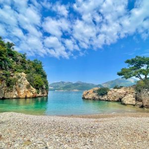 Atemberaubender Meerblick auf eine türkisfarbene Bucht an der lykischen Küste – umgeben von grünen Pinien und Felsen.
